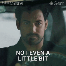 a man driving a car with the words not even a little bit behind him