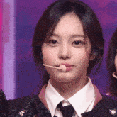 a close up of a girl wearing a microphone in her mouth