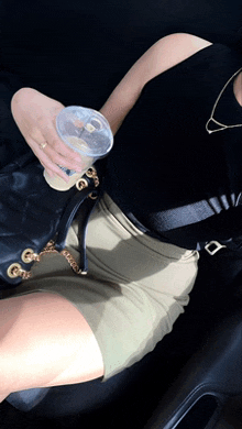 a woman sitting in a car holding a cup