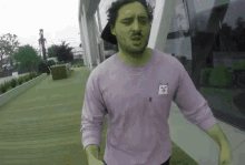a man wearing a purple shirt with a cat on the pocket