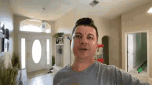 a man in a grey shirt is standing in front of a popcorn machine in a living room