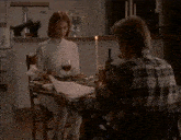 a woman sits at a table with a man holding a piece of paper