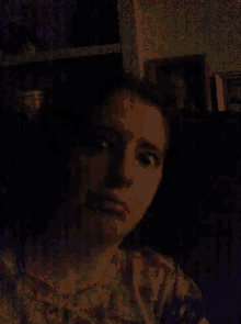 a person is taking a selfie in a dark room with a blurry background .