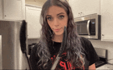 a woman in a black shirt with the word evil on it