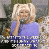 a woman is smiling while talking on a phone and says what it 's the weekend and it 's sunny
