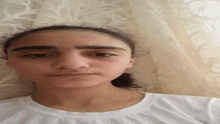 a close up of a woman 's face in front of a curtain