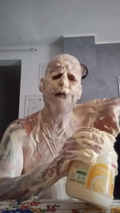 a man covered in mayonnaise is holding a jar