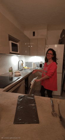 a woman in a pink sweater is standing in a kitchen holding a dishwasher