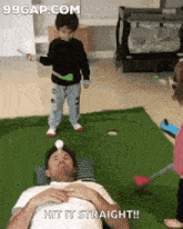 a man laying on a pillow with a child playing golf and the words hit it straight written on the screen