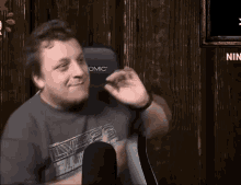a man is sitting in front of a microphone in a chair .
