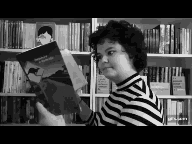a black and white photo of a person reading a book called aventura
