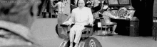 a man is sitting in a wheelchair in front of an arcade machine in a black and white photo .