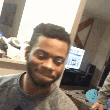 a man with a beard is making a funny face in front of a computer screen