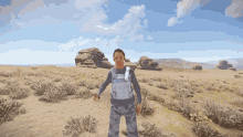 a man in a military uniform stands in a desert landscape