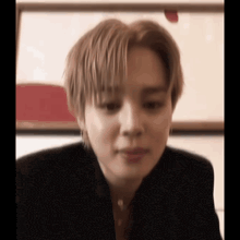 a close up of a person 's face with a blurry background and a painting in the background .