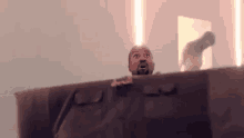 a man is sitting on a couch in a dark room with a light shining on him .