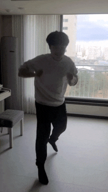 a man is dancing in front of a large window