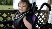 a young boy in a wheelchair has a warning label on the back of his seat