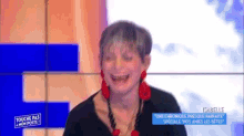 a woman is laughing in front of a sign that says touche pas a mon poste