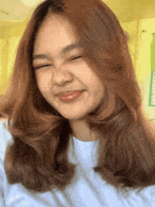 a girl with long brown hair is smiling and making a face
