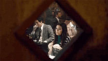 a man smoking a cigarette in a restaurant while a woman looks on