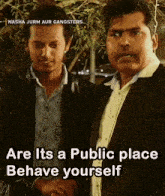 two men are standing next to each other and one of them says " are its a public place behave yourself "