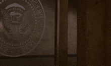 a man stands in front of a presidential seal