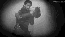 a black and white photo of a man and a woman dancing .