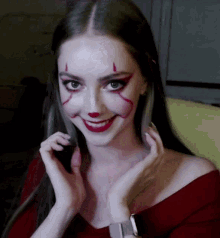a woman with a clown face painted on her face is smiling