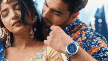 a man is kissing a woman on the neck while she is wearing a watch .