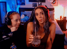 a woman wearing headphones holds a glass with a straw in her hand