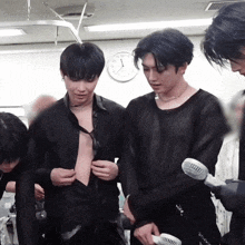 a group of young men are standing in a room with a clock on the wall that shows the time as 4:20