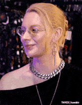 a close up of a woman wearing glasses and a necklace with a cross