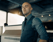 a bald man in a suit and tie stands in front of a kepler logo