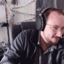 a man wearing headphones is sitting in a chair .