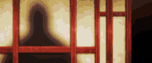 a shadow of a person is cast on a wall behind a wooden door