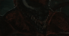 a close up of a monster in a dark room with a blurred background