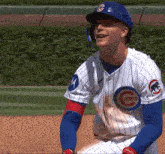 a man wearing a cubs jersey is smiling on the field