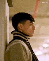 a young man leaning against a wall with the word canirove written below him