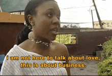 a woman is standing in front of a building and talking about love .