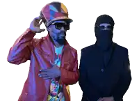a man wearing a hat and sunglasses stands next to another man wearing a mask