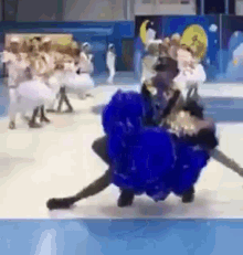 a group of people are dancing on a blue and white striped floor .