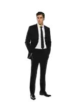 a man in a black suit and tie stands with his hands in his pockets