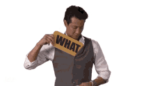 a man is holding a sign that says what on it