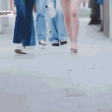 a woman wearing a mask is walking down a street with a man walking behind her .