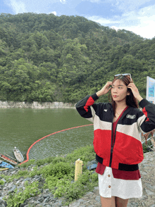 a woman wearing a red white and black jacket with the word tnt on the front