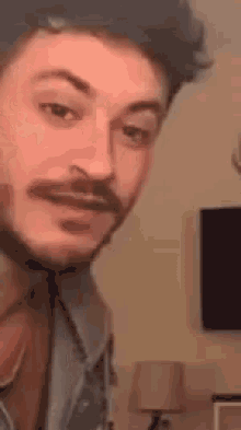a man with a beard is making a funny face .