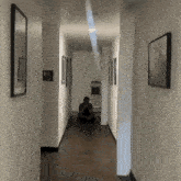 a man sits in a hallway next to a handicapped sign