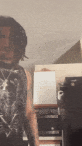 a man with dreadlocks is wearing a black tank top with a skull on it