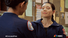 two female firefighters are standing next to each other with their eyes closed and #chicagofire written on the bottom